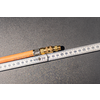 Orange hose with brass fitting lies diagonally on a dark textured surface; a white folding ruler with centimeter markings lies beside it, numbers visible