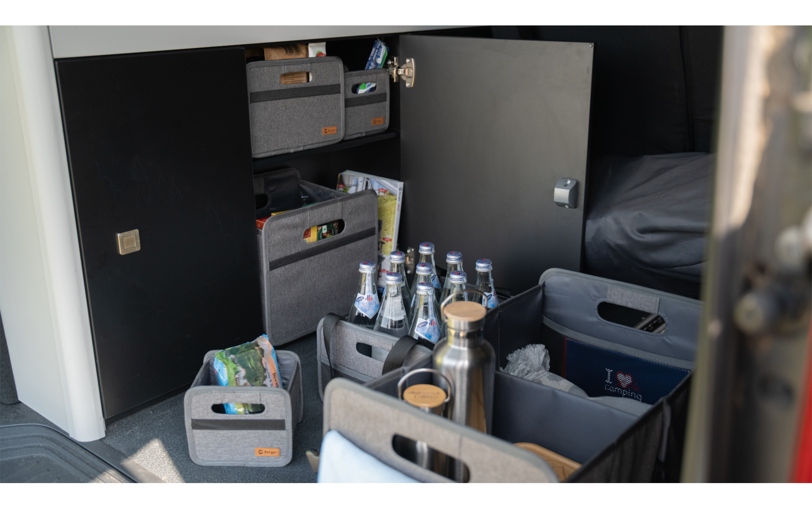 Placards et tiroirs de cuisine ouverts avec différents aliments et boissons