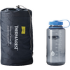 Dunkelgrauer Packsack mit Aufschrift 'THERM-A-REST' neben einer transparenten Trinkflasche mit blauem Schraubverschluss und Skala