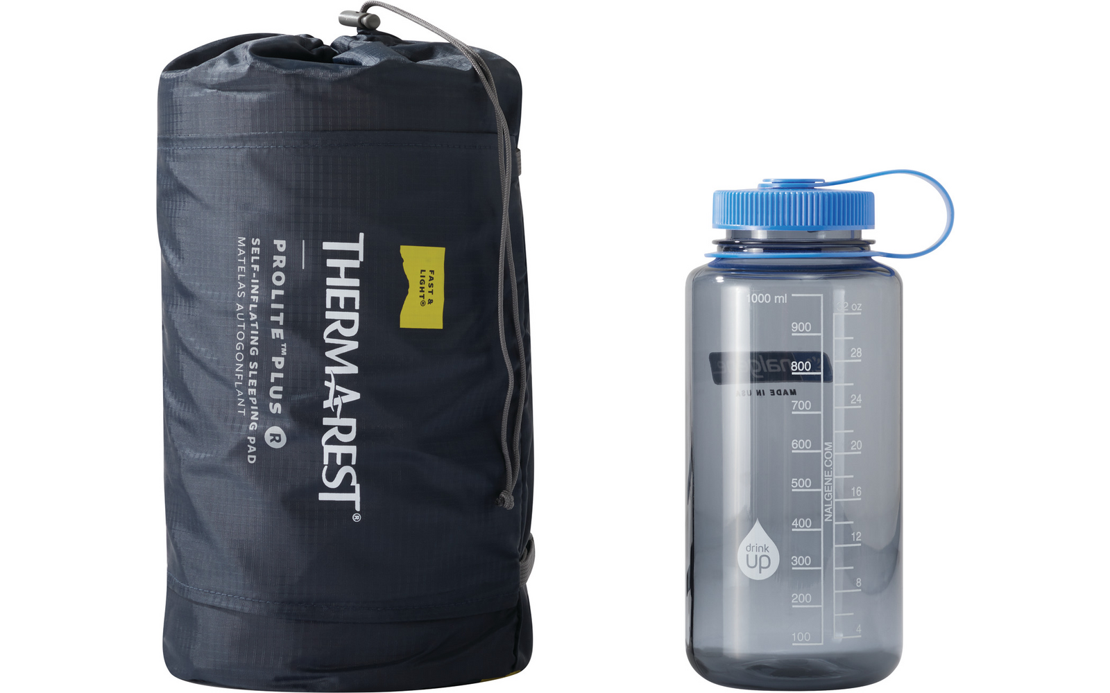 Dunkelgrauer Packsack mit Aufschrift 'THERM-A-REST' neben einer transparenten Trinkflasche mit blauem Schraubverschluss und Skala