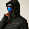Person trägt schwarze Skikleidung mit Helm und reflektiver Skibrille