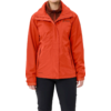 Personne portant une veste rouge et un pantalon noir, buste visible, fond blanc