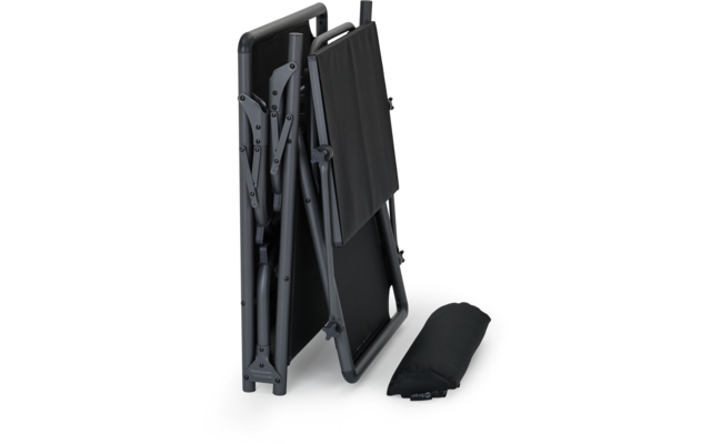 Gefalteter Campingtisch und zusammengelegte Campingstühle in schwarz