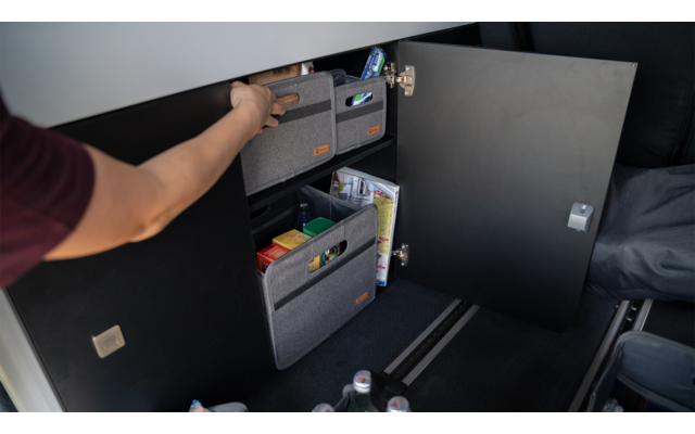 Main ouvre une armoire grise avec des dossiers colorés à l'intérieur