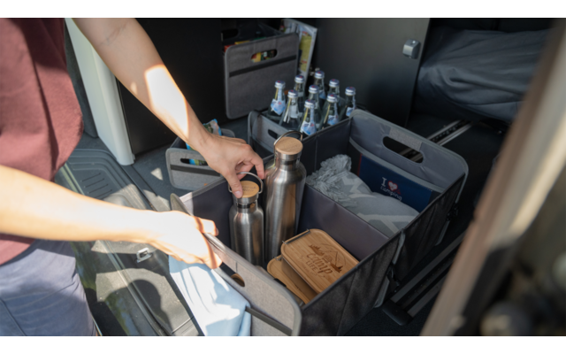 Des mains manipulent un levier de vitesse et des boutons dans un véhicule