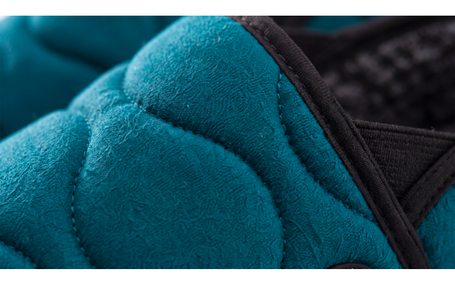 Gros plan d'un rembourrage matelassé turquoise avec bordure noire et tissu en maille noir