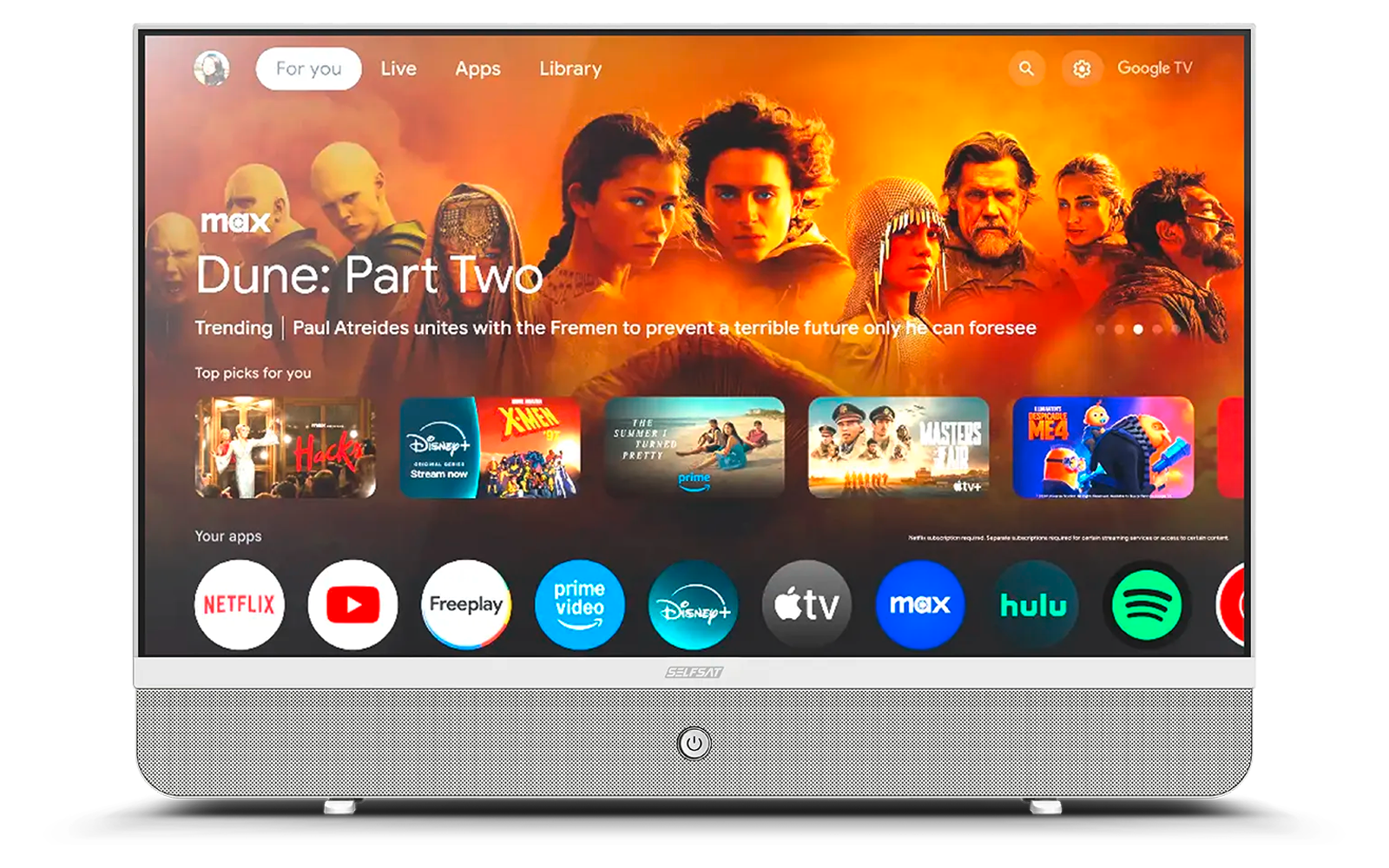 Televisore piatto su piedistallo che mostra la schermata principale di streaming: banner arancione con la scritta "Dune: Part Two" e ritratti dei personaggi; sotto una fila di icone di app come Netflix, YouTube, Prime Video, Disney+, Apple TV, Max, Hulu, Spotify