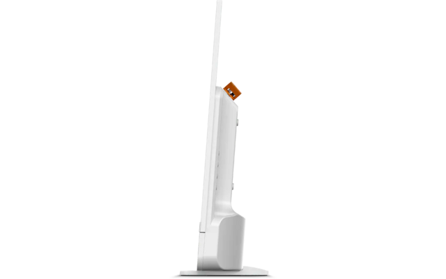 Dispositivo bianco e sottile in posizione verticale su una base rettangolare; lungo stelo verticale sottile; piccolo connettore arancione visibile sul retro