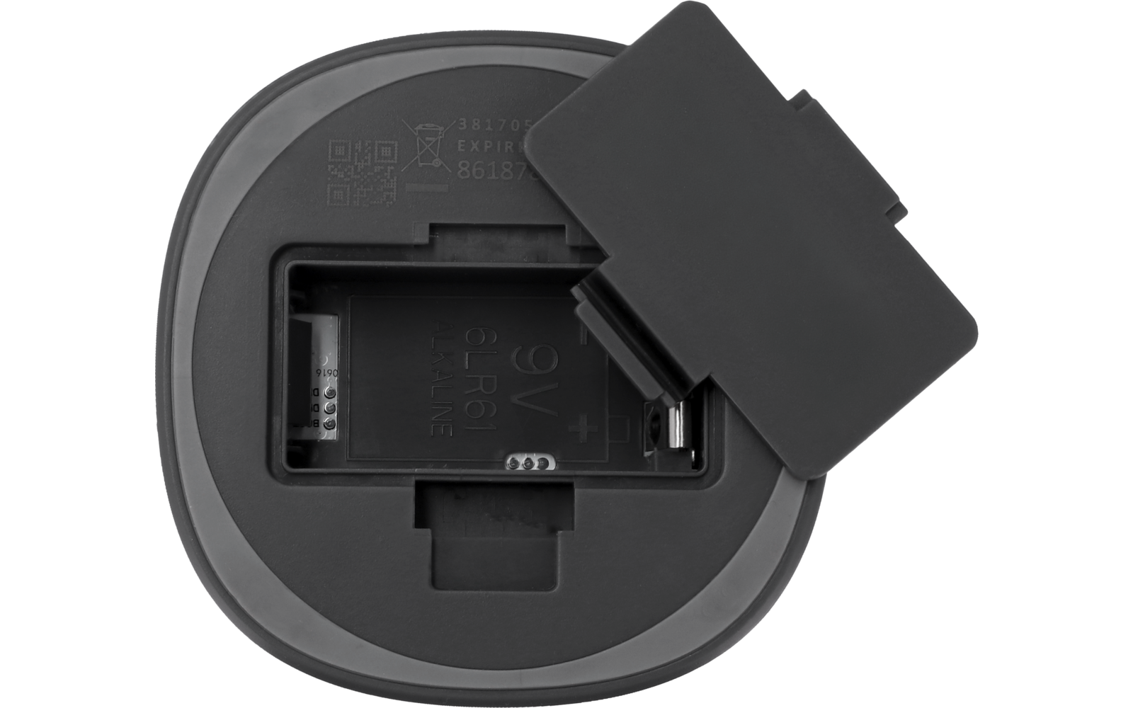 Rundes graues Gerät mit offenem rechteckigem Batteriefach, sichtbaren Metallkontakten und abgenommenem rechteckigen Deckel daneben