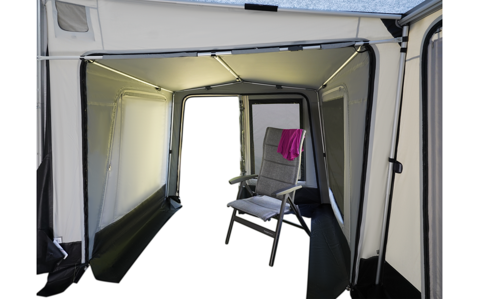 Innenraum eines hellgrauen Vorzelts mit Metallgestänge; rechts ein grauer Klappstuhl mit Polster, an der Rückenlehne hängt ein pinkes Handtuch, der vordere Durchgang ist offen