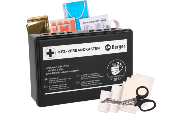 Schwarze Kunststoffbox mit Aufdruck 'KFZ-VERBANDKASTEN' und Logo 'Berger'; davor Schere, Pflasterstreifen, blaues Einweg-Mund-Nasen-Tuch, Reinigungstuch, silberne Rettungsfolie, weiße Klebebandrolle