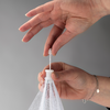 Hand hält weißen Plastikbeutel am Zugband