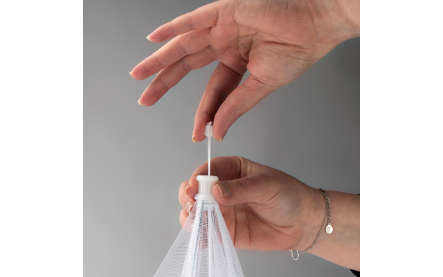 Hand hält weißen Plastikbeutel am Zugband