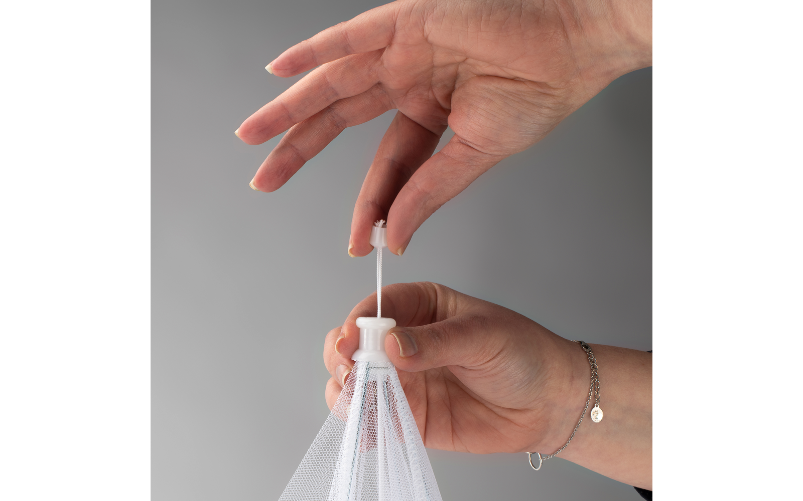 Hand hält weißen Plastikbeutel am Zugband