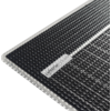 Gros plan d'un tapis noir texturé avec une bordure argentée et une étiquette blanche portant un texte foncé dans un coin