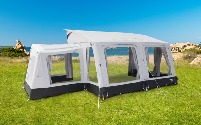 Großes weißes Partyzelt mit Fenstern auf einer grünen Wiese bei sonnigem Wetter