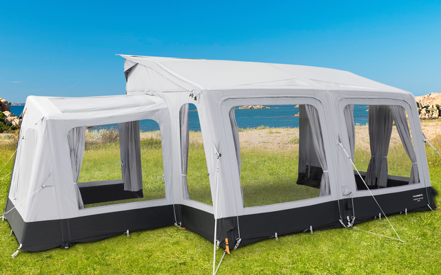 Gran carpa blanca para fiestas con ventanas sobre un césped verde en clima soleado