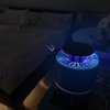 Luftbefeuchter mit blauem Licht auf einem Nachttisch neben einem Bett