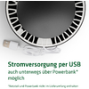 Nahaufnahme eines USB-Ladegeräts und eines USB-Kabels vor einem runden schwarzen Objekt mit weißen Markierungen