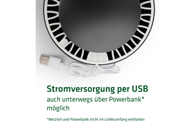 Nahaufnahme eines USB-Ladegeräts und eines USB-Kabels vor einem runden schwarzen Objekt mit weißen Markierungen