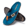 Blue flip-flop sandal with black lug sole, orange stitching and toe post, one sandal crossed over the other on a white background