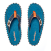 Two blue flip-flops side by side, top view, orange strap accents, Gumbies text on the insoles, black tread soles visible, white tag on the strap