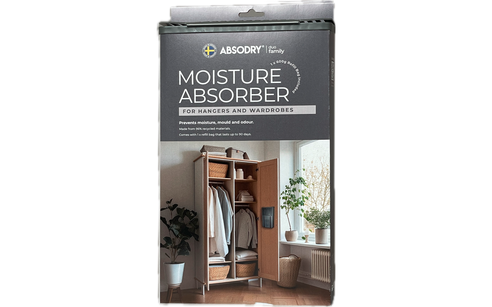 Packung mit Luftentfeuchter vor weißer Wand und Holzboden, daneben Pflanzen und Garderobe