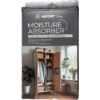 Packung mit Luftentfeuchter vor weißer Wand und Holzboden, daneben Pflanzen und Garderobe