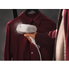 Hand houdt witte kledingstomer met AEG-logo tegen een donkerrood hangend overhemd aan een zwarte hanger