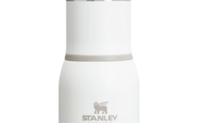 Witte fles met zilverkleurige schroefdop en zilveren bodem, grijze ring bij de hals en bedrukt 'Stanley'-logo