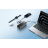 Laptop mit aufgeklapptem Bildschirm, daneben eine Maus, ein Ladekabel und ein USB-Stick auf einer weißen Oberfläche