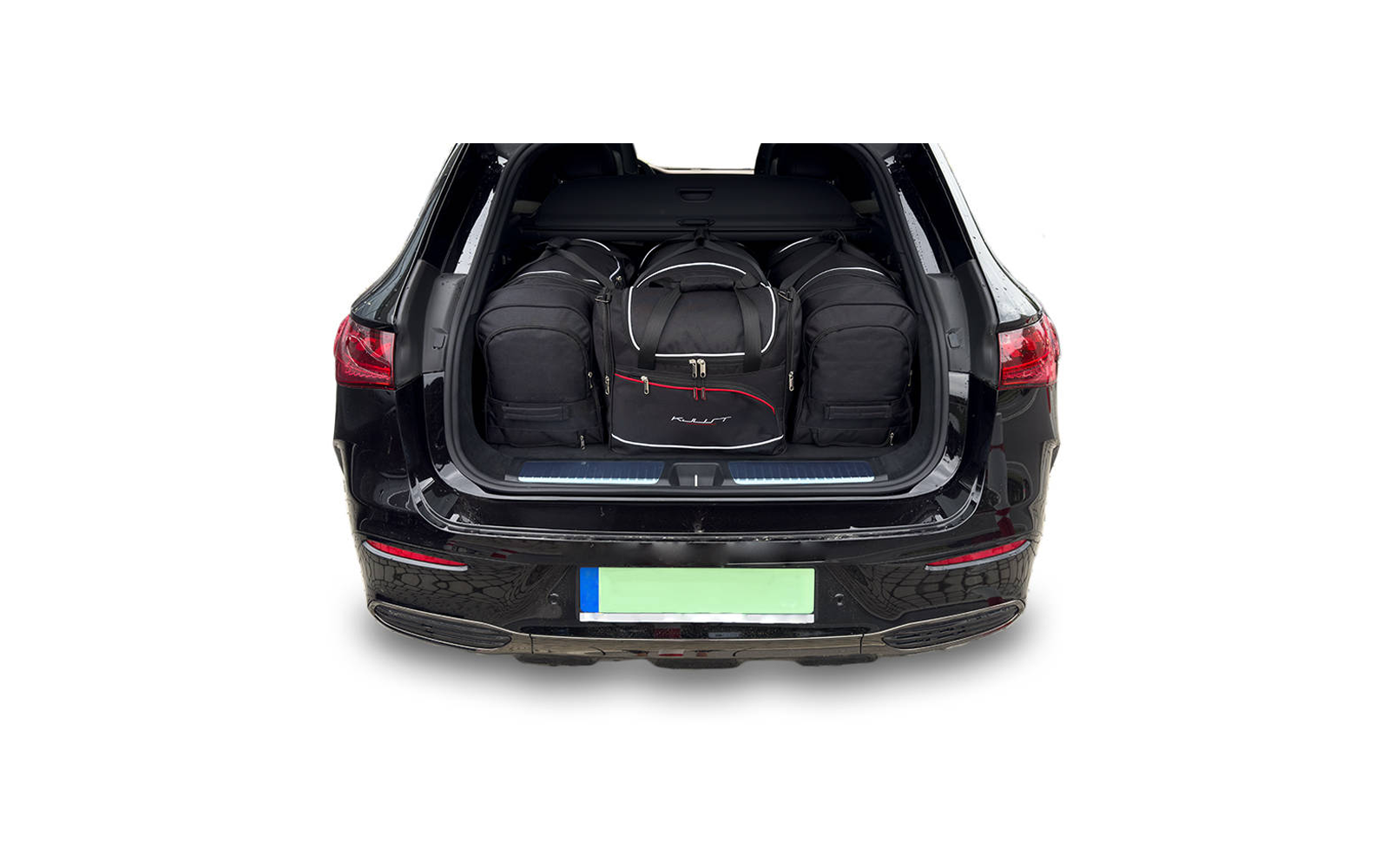 Coffre ouvert d'une voiture noire contenant plusieurs sacs de voyage et sacs à dos noirs