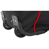 Gros plan du coin inférieur d'une valise en tissu noir avec passepoil rouge, deux roues noires et une protection d'angle en plastique