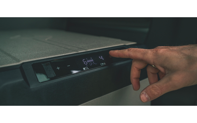 Rechte Hand berührt digitales Bedienfeld mit beleuchteten Symbolen und Zahlen