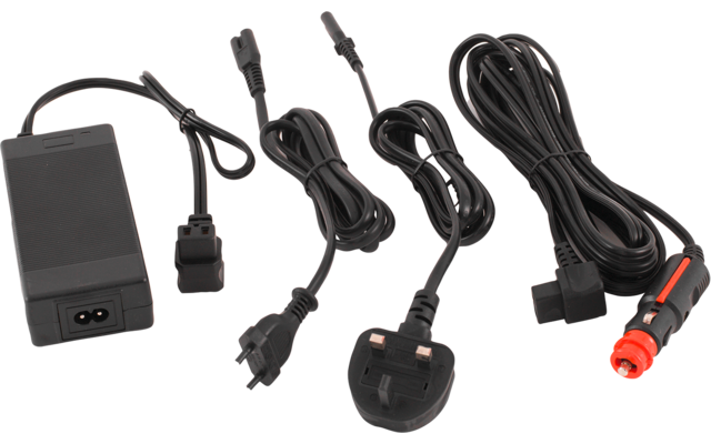 Mehrere schwarze Stromkabel und Adapter nebeneinander: ein rechteckiges Netzteil mit Kabel, ein dreipoliger britischer Stecker, ein Kfz-Zigarettenanzünderstecker mit rotem Ende und weitere Kabel mit runden Steckverbindungen