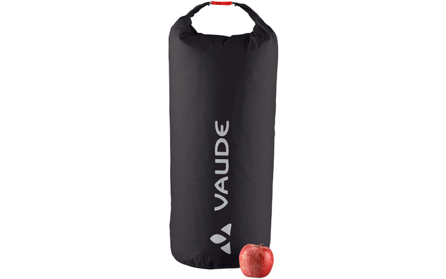 Schwarze wasserdichte Tasche mit weißem Vaude-Logo und rotem Verschluss, daneben ein roter Apfel