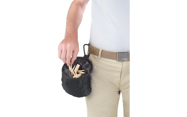 Oberkörper und Hüfte einer Person mit weißem T‑Shirt und beiger Hose samt Gürtel; kleine schwarze Stofftasche mit mehreren hölzernen Wäscheklammern, Hand hält eine Klammer