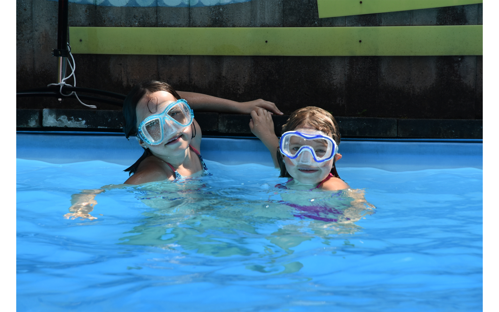 Zwei Personen mit Schnorchelmasken schwimmen in einem Pool und halten Händchen