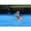 Kind mit Schwimmbrille im Wasser eines Schwimmbeckens