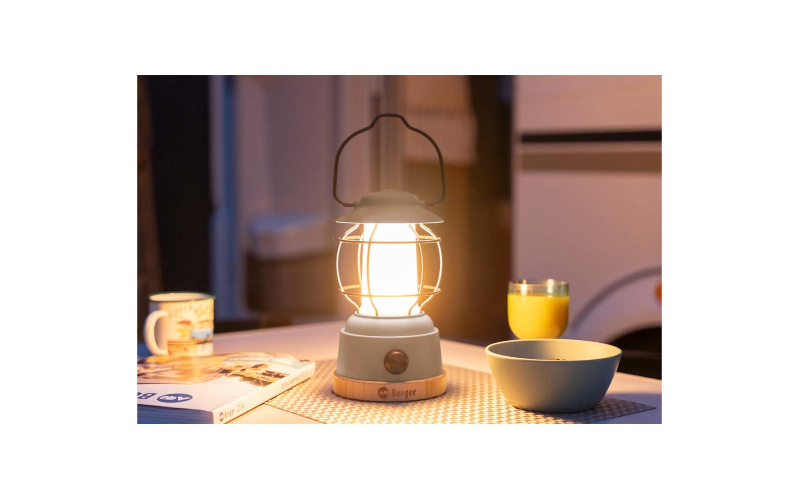 Een brandende lantaarn op een tafel met servies en drinken