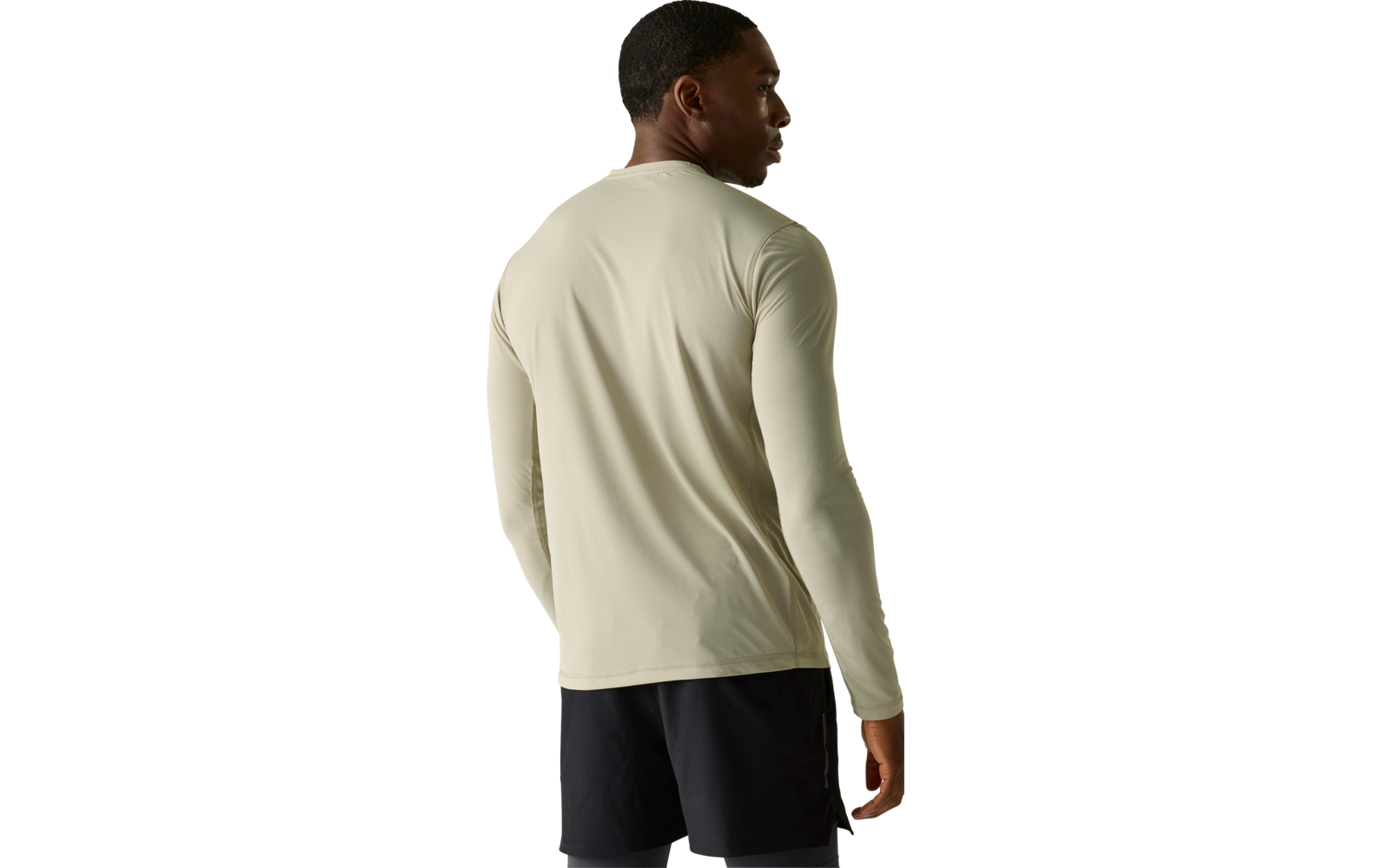 Person von hinten in hellbeigem langärmeligen Shirt und schwarzen Shorts vor neutralem Hintergrund