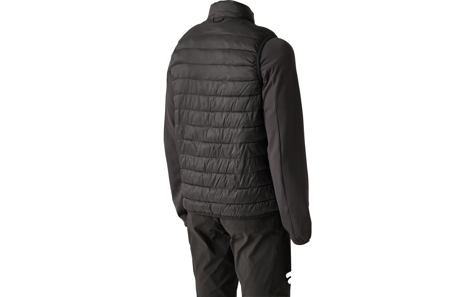 Persona vista da dietro con gilet imbottito nero sopra una maglia nera a maniche lunghe e pantaloni scuri, sfondo chiaro