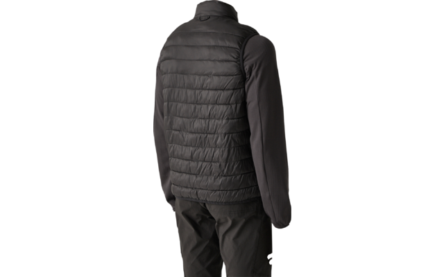 Persona vista da dietro con gilet imbottito nero sopra una maglia nera a maniche lunghe e pantaloni scuri, sfondo chiaro