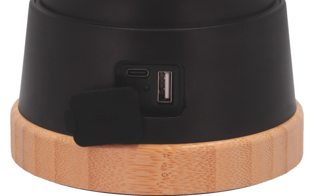 Gros plan d'un objet noir avec un port USB et un anneau en bois en bas