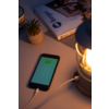 Smartphone avec écran allumé à côté d'une lampe et d'une petite plante