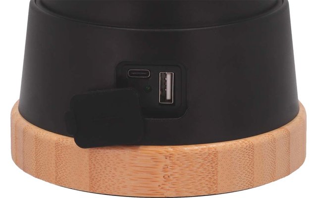 Close-up van een zwart object met een USB-poort en een houten ring aan de onderkant