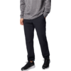 Unterkörper einer Person mit grauem Pullover, schwarzen Hosen und schwarzen Sportschuhen