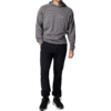 Ein Mann trägt eine graue Sweatshirt und schwarze Hose