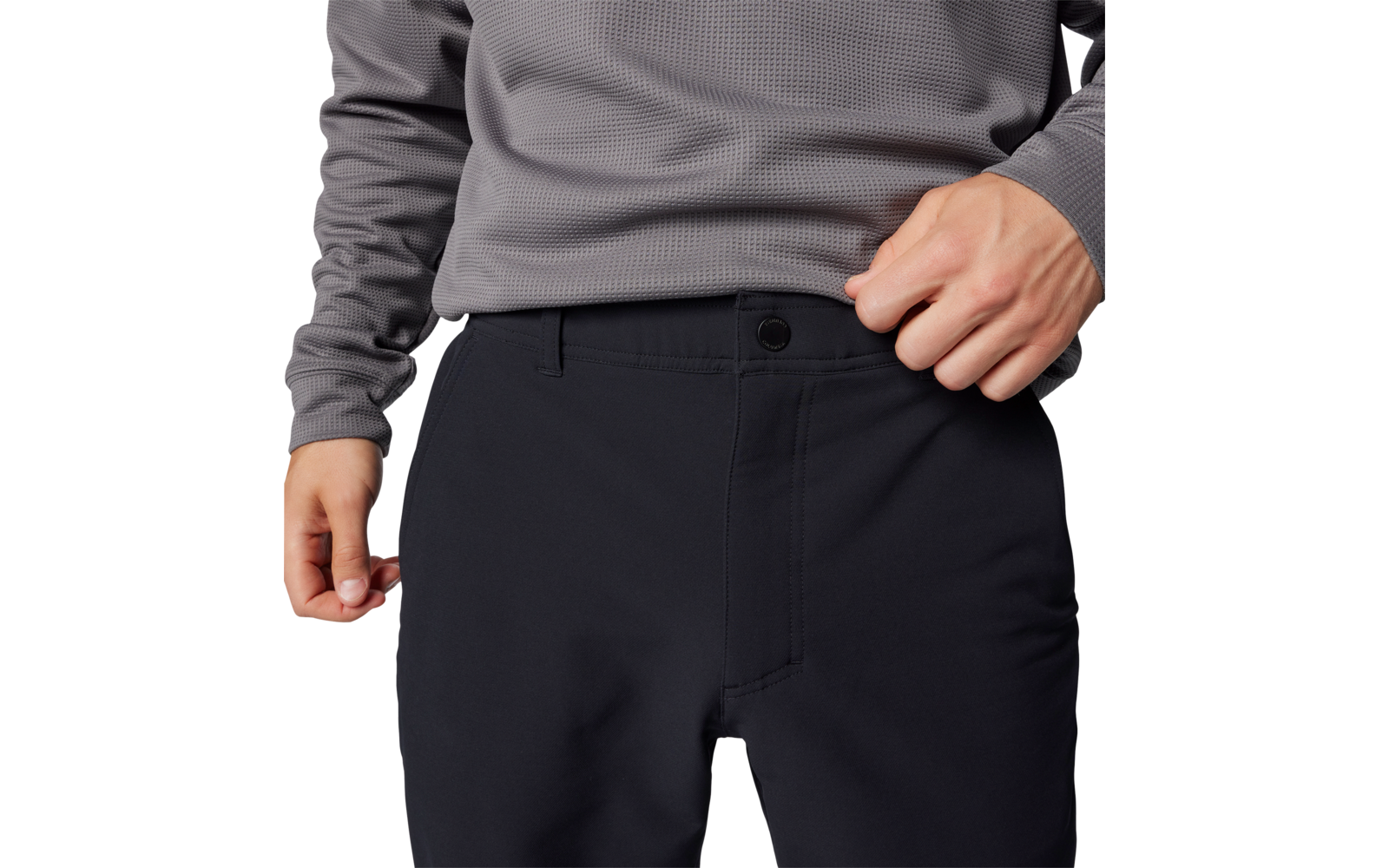 Person trägt dunkelblaue Hose und grauen Pullover, Hände in der Nähe der Hosentasche