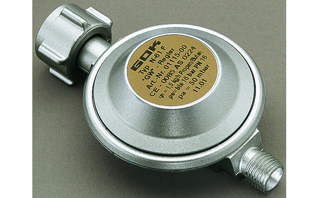 Runder silberner Metallkörper mit goldfarbenem runden Aufkleber mit schwarzem Text, links oben ein grauer Kunststoffanschluss und rechts unten ein Metallgewinde